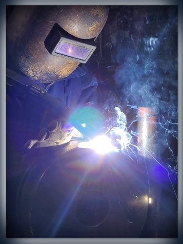 Man wearing mask using welding machine